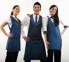 due donne e un uomo al centro con camici blu scuro