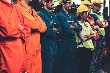 primo piano di divise ignifughe di vicili del fuoco e protezione civile con tute arancioni e giubbini gialli catarifrangenti